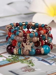 Detail eines böhmischen mehrlagigen Perlenarmbands mit blauen Steinen und Schmetterling
