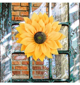 Artistic yellow sunflower wreath displayed on a rustic vintage wooden window frame backdrop