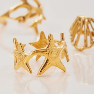Macro shot of 18K gold plated stainless steel starfish ring with intricate metal texture