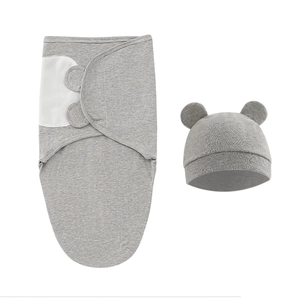 Detail of grey newborn swaddle sack and matching bear ear hat in soft knitted cotton fabric