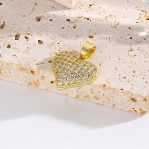 Macro shot of gold heart-shaped pendant with sparkling clear crystals on stone