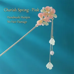 Detailed shot of handmade metal hair stick with pink gradient flowers and tassel pearls