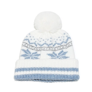 Close-up of winter knit hat with large white faux fur pompom and snowflake pattern details
