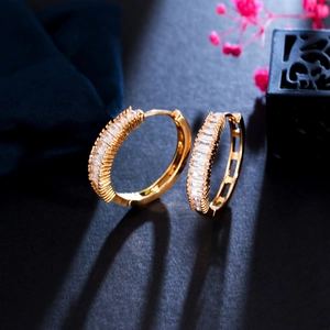 Detail of gold hoop earrings with channel-set rectangular baguette cubic zirconia stones