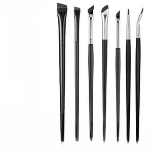 Detail of 7 professional makeup brushes with black handles and silver ferrules
