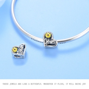 Detailed macro view of S925 sterling silver heart charm with cat and sunflower enamel