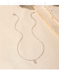 Détail du collier cœur en argent S925 avec pierre précieuse sur surface en pierre