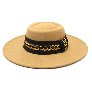 Close-up of camel wool fedora hat featuring wide brim and gold chain link ribbon band