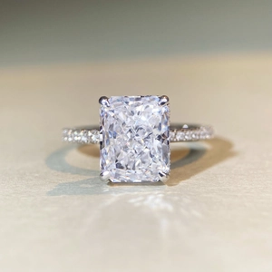 Macro shot of a rectangular radiant cut gemstone ring with a pavé diamond band setting