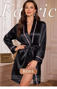 Detail of black satin robe with pink piping trim and silky smooth texture close-up
