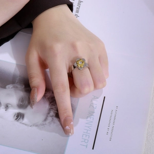 Close-up of two-tone flower ring with silver band, gold petals and sparkling zircon