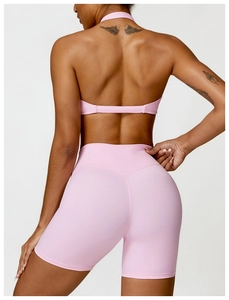 Rear view of pink seamless yoga set featuring halter sports bra and high waist shorts