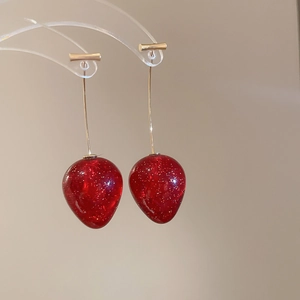 Détail de boucles d'oreilles fraises rouges avec paillettes dorées et crochets