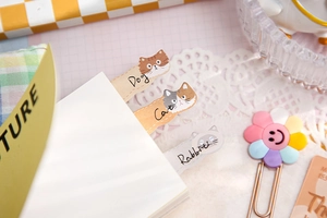 Detailed view of cute cat-shaped paper index tabs tucked inside a white notebook