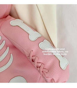 Close-up of pink litchi leather texture with white bone patchwork and lace-up detail