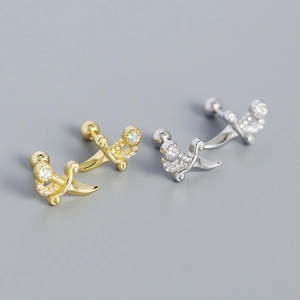 Detailed macro view of gold and silver dagger-shaped earrings with diamond accents