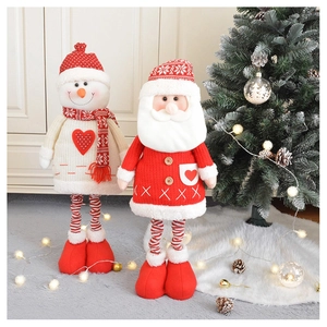 Detail of plush Santa and Snowman ornaments with knitted legs by a Christmas tree
