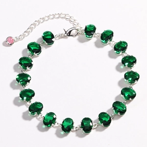 Fashion silver bracelet with emerald green oval zircons on a clean white background