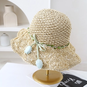 Handmade straw sun hat with wide brim and tulip pendant detailing.