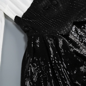 Détail de broderies perlées et de paillettes sur une robe blazer bicolore noir et blanc