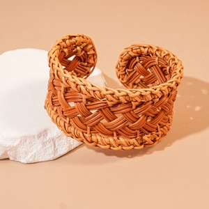Detail shot of handwoven geometric rattan cuff bracelet with intricate mesh texture