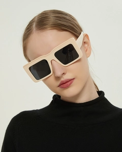 Detail shot of stylish cream-white thick frame sunglasses with dark black lenses on model