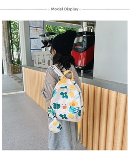 Cute floral print toddler backpack with matching small coin purse shown in a cafe