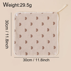 Detail of baby cotton bib with pom-pom trim and rainbow print measuring 30cm and 29.5g