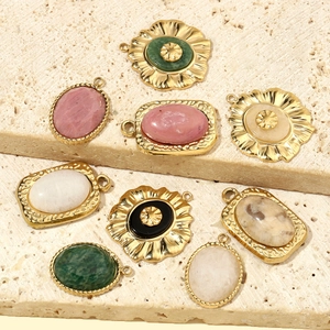 French oval natural stone pendants in gold titanium steel on beige travertine stone