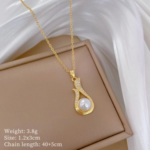 Macro detail of gold teardrop pearl pendant with diamond accents on white silk