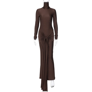 Détail d'une robe marron à col montant et manches longues avec nœud et ruban au sol