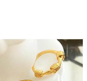 Foto macro de anillo de acero de titanio chapado en oro 18K con detalle de nudo trenzado