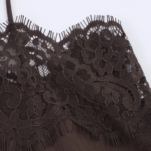 Close-up of deep brown eyelash lace trim detailing and sheer floral pattern on silk top