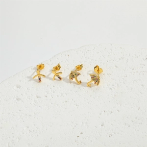 Golden umbrella and bow earrings set with colorful cubic zirconia on white stone