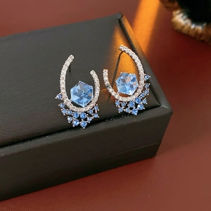 Detail of blue hexagonal zircon earrings with micro-inlaid diamonds on a U-shaped frame