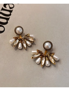 Détail de boucles d'oreilles vintage en perles et cristaux, forme éventail dorée