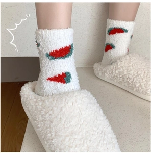 Detailed view of thick coral fleece socks with red chili pattern for winter comfort