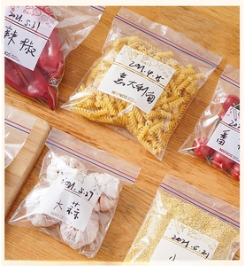 Detail of multi-size food storage bags with write-on labels and double seals on wood desk