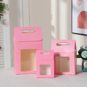 Detailed view of three pink gift boxes with clear window and handles in small medium and large