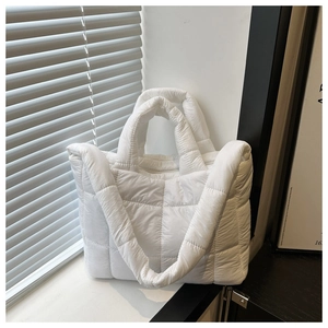 Detail of white quilted tote bag with soft down texture and natural lighting scene