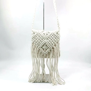Detail of bohemian macramé shoulder bag featuring ivory cotton weave and long fringe trim
