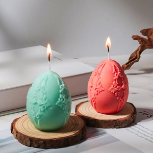 Retro relief floral Easter egg candles in mint green and coral pink on wood