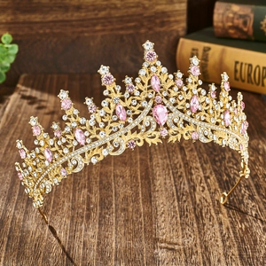 Detail of bridal crown with pink crystals and gold metal on vintage wooden surface