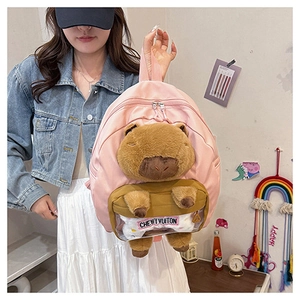 Pink nylon backpack detail with a 3D plush capybara doll and clear PVC pocket