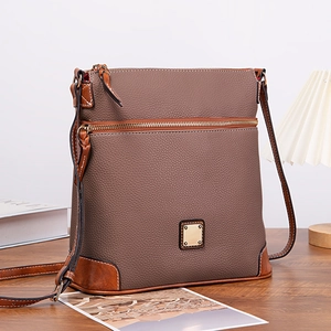 Macro detail of textured lychee grain leather crossbody bag with smooth corner accents
