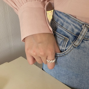 Close-up of a minimalist 925 sterling silver twisted rope ring worn on a female model's finger