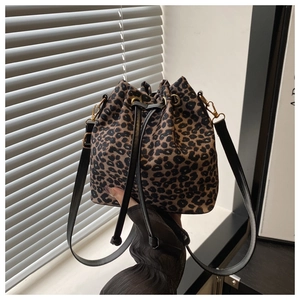 Détail du sac seau à motif léopard avec cordons noirs et ferrures dorées élégantes