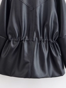 Detail of black leather jacket featuring elastic drawstring waist and textured grain