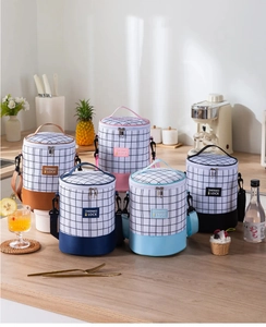 Five assorted insulated cylinder lunch bags in various colors on a kitchen countertop