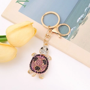 Close-up of golden turtle keychain with pink rhinestones and a lobster clasp